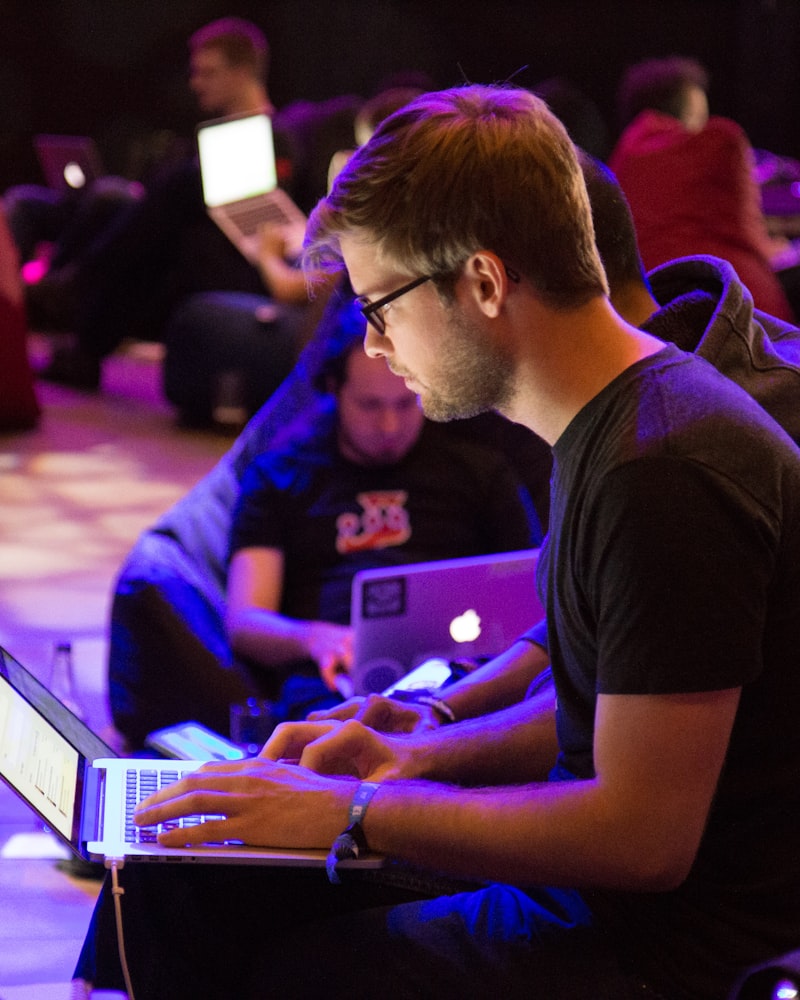 Young man coding on a laptop during an IT training session
